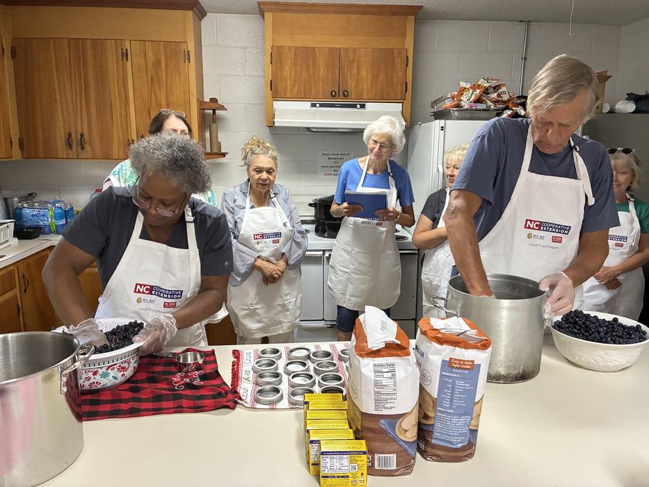 volunteers learning about canning in a kitchen