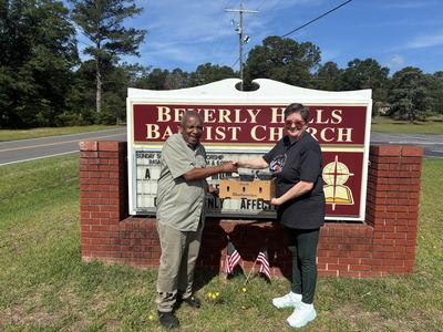 two people shake hands and receive a produce box