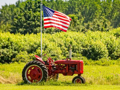 tractor in a field with an American flag