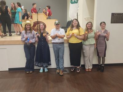 Youth showing the medals and ribbons they won.