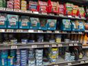Cans of tuna on shelf at grocery store.