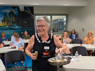 Extension Master Food Volunteer is Margarete O'Leary from Supply demonstrating how to bloom a spice mixture to get the best flavors.
