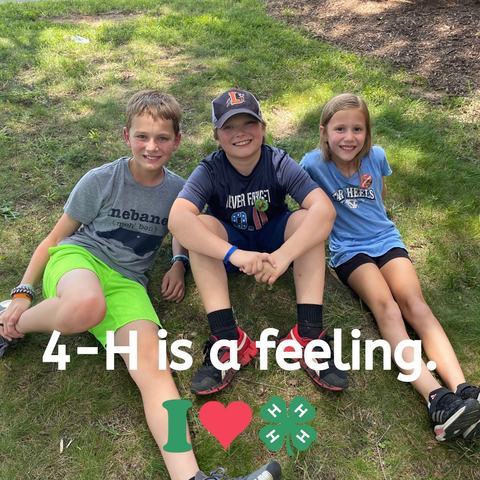 4-H'ers sit together with the text "4-H is a feeling" super imposed.