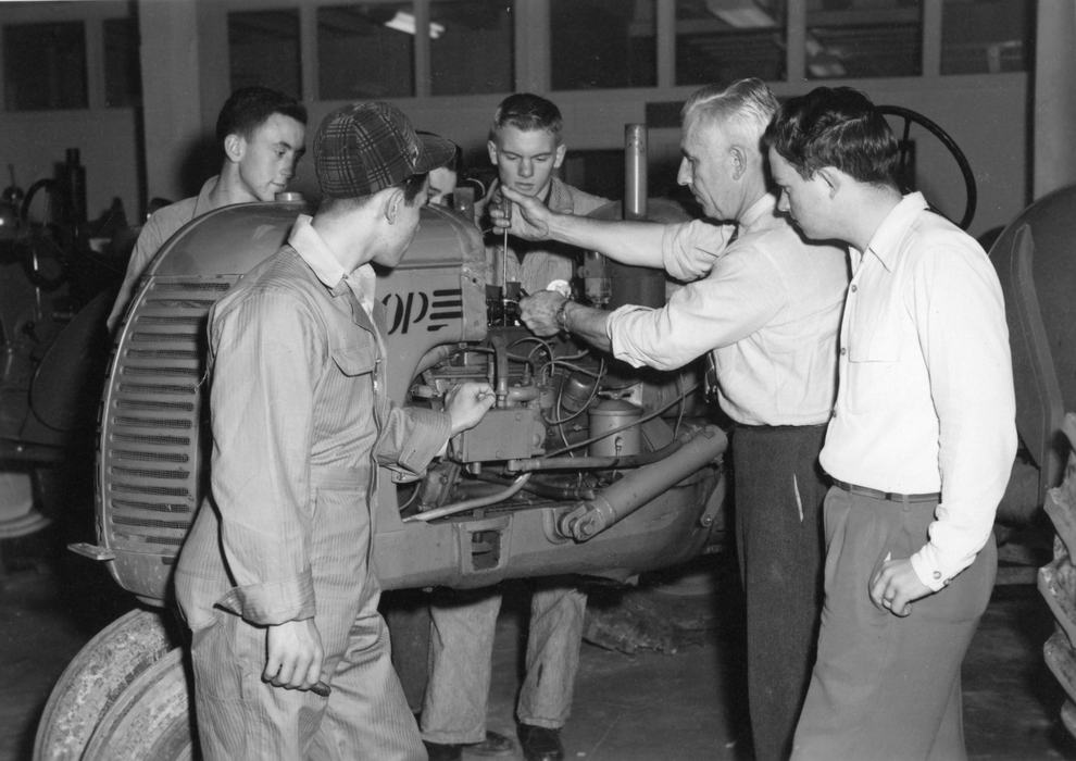 1952 from the NCSU Libraries Rare and Unique Digital Collections ~ Junior Parrish of Swain County is pictured. CAPTION: 4-H instructor Ferguson adjusting the valves on a tractor at a 4-H tractor program in front of, left to right, Justice Ammons of Madison County, Allen Bleims of Allegheny County, Junior Parrish of Swain County and Larry Best of Iredell County