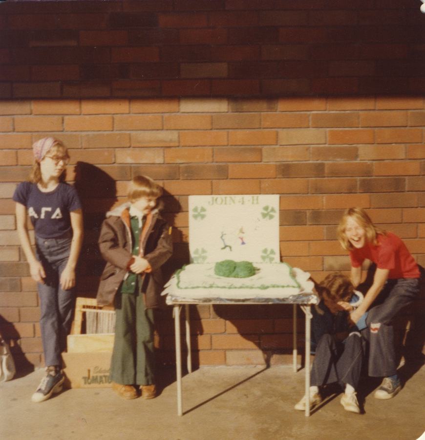 4-Hers with 'Join 4-H' sign and cake.