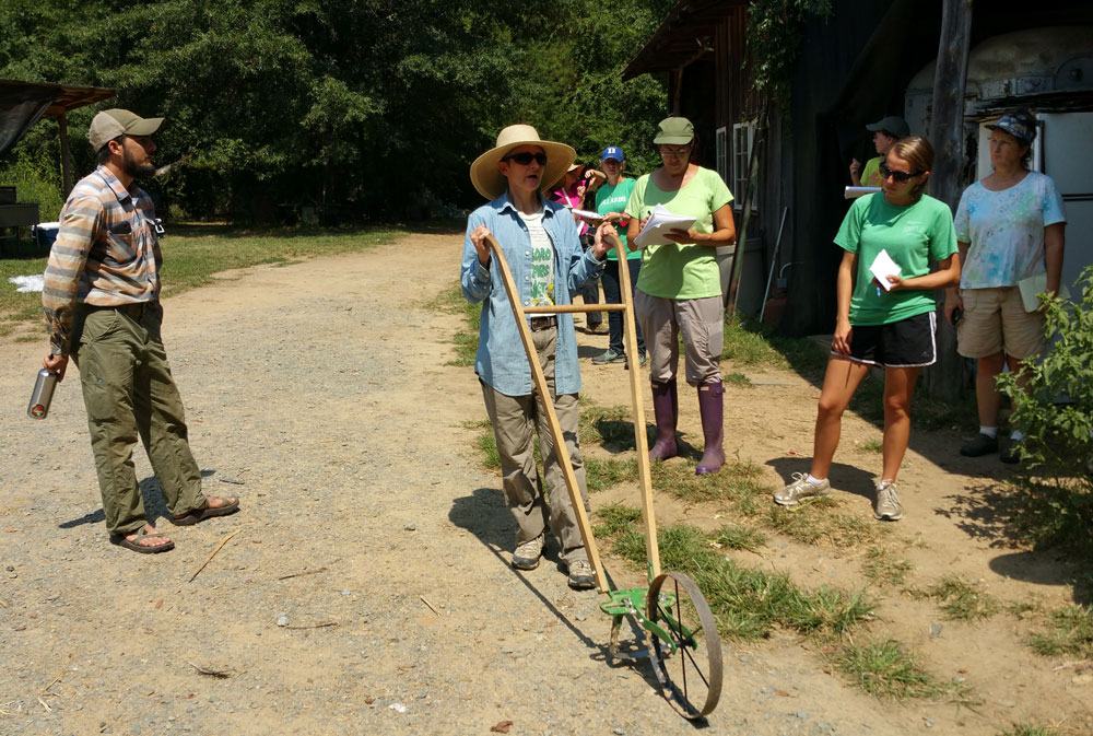 Leah Cook demonstrates a wheel hoe.