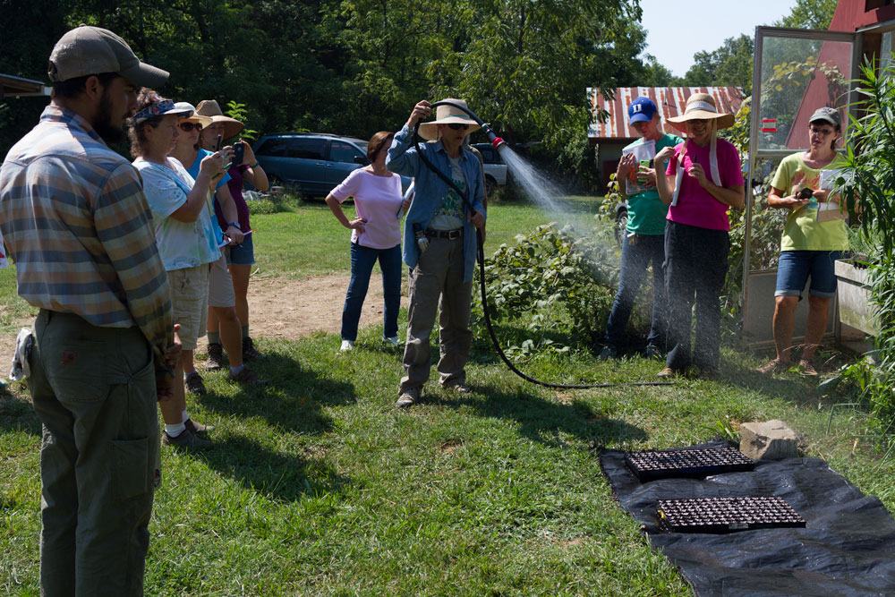 Both Cathy and Leah discussed how important proper watering was in the greenhouse.  Leah demonstrates how to water newly seeded flats without washing seed away.