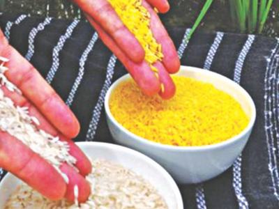 Hands sprinkling white and yellow rice into two bowls on striped fabric