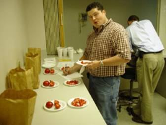 Person at taste test table sampling tomatoes