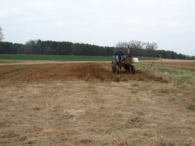 Farmer driving a tractor plowing a rural field