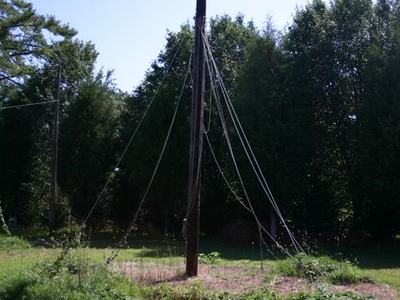 Wooden central pole with multiple guy wires anchored around a circular grassy area
