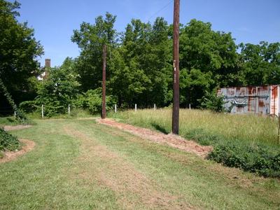 Mowed grassy track with utility poles leading to trees and a rusted shipping container