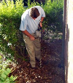 Using a gas-powered auger to install a termite bait station