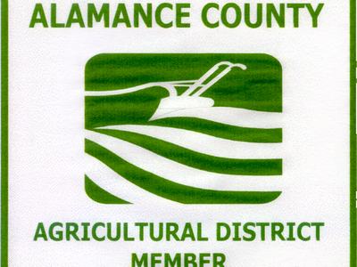 Alamance County Agricultural District Member logo with stylized plow and fields