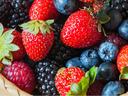 Basket of mixed berries: strawberries, blueberries, blackberries, and raspberries in a woven basket