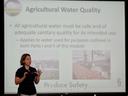 Woman presenting slide titled "Agricultural Water Quality" about safe agricultural water