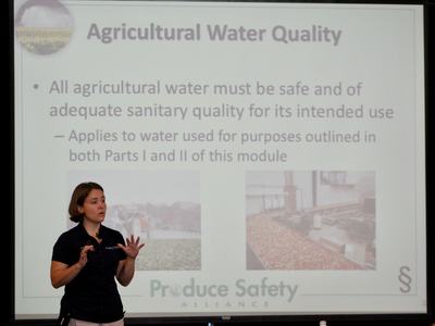 Woman presenting slide titled "Agricultural Water Quality" about safe agricultural water