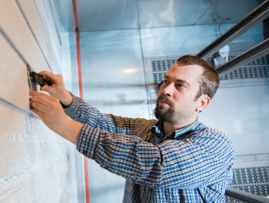 faculty member working with siding