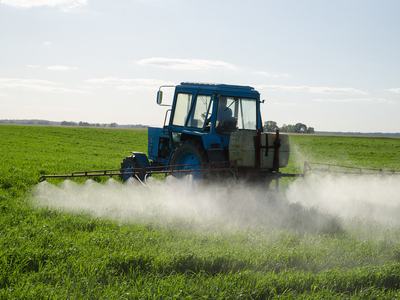 tractor spraying pesticide in field