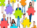 People holding large colorful jigsaw puzzle pieces