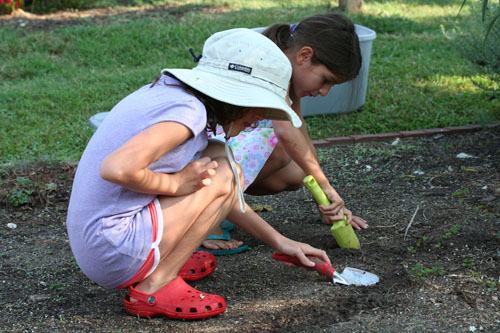 Girls planting seeds in the garden