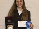 Young woman holding an award belt in a box, an envelope, and a blue ribbon