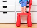 kids safety concept- little girl climbing on baby chair