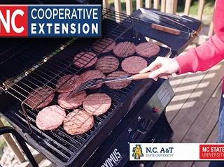 Person flipping burger patties on gas grill; 'NC Cooperative Extension' banner and university logos