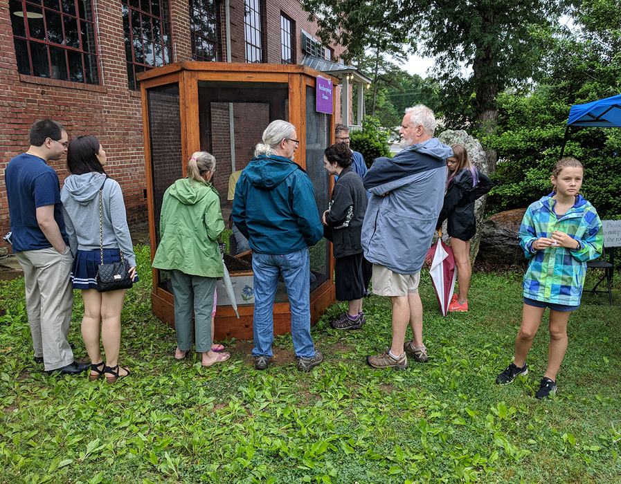 Apiary Inspector Supervisor Don Hopkins does a beekeeping demo in the bee cage. 