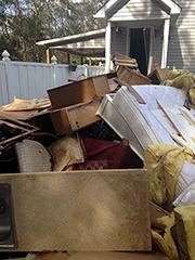 Household furnishings piled outside of flooded house
