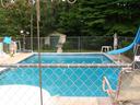 A swimming pool behind a house
