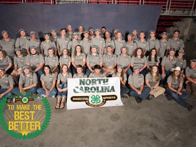 Large group in gray shirts holding "NORTH CAROLINA SHOOTING SPORTS" banner