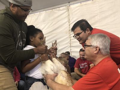 Participants and judges holding a turkey for judging