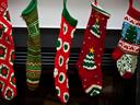 5 Christmas stockings hung on fireplace mantle