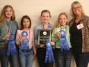 Four girls and an adult with blue ribbons and plaque reading "NC 4‑H Horse Judging Contest Junior Team 2019"