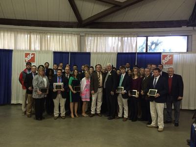 Group of people posing indoors, several holding plaques, backdrop with "ASC" signs.