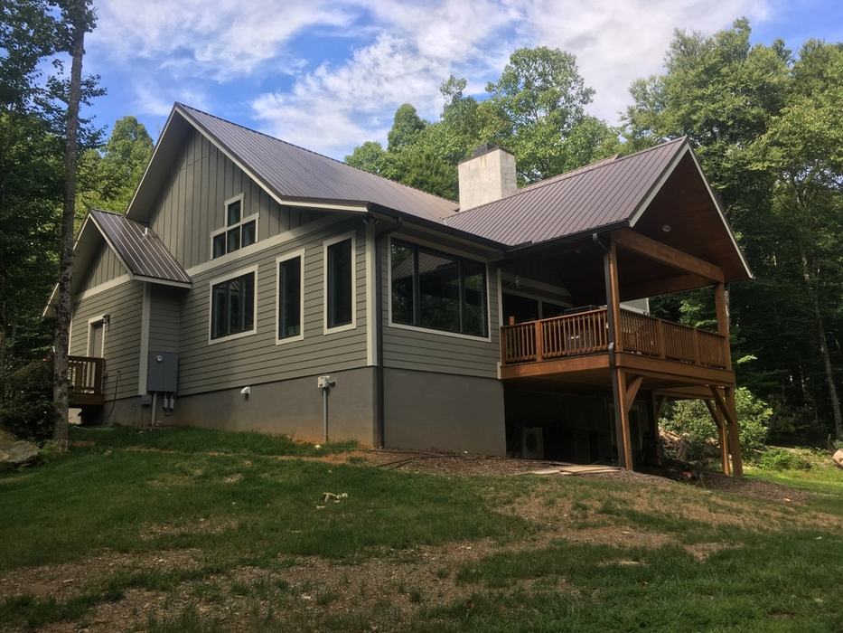 New home surrounded by sloping lawn.