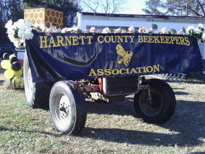Decorated trailer with banner "HARNETT COUNTY BEEKEEPERS ASSOCIATION" and bee logo