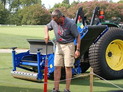 Turf student with tractor on golf course green