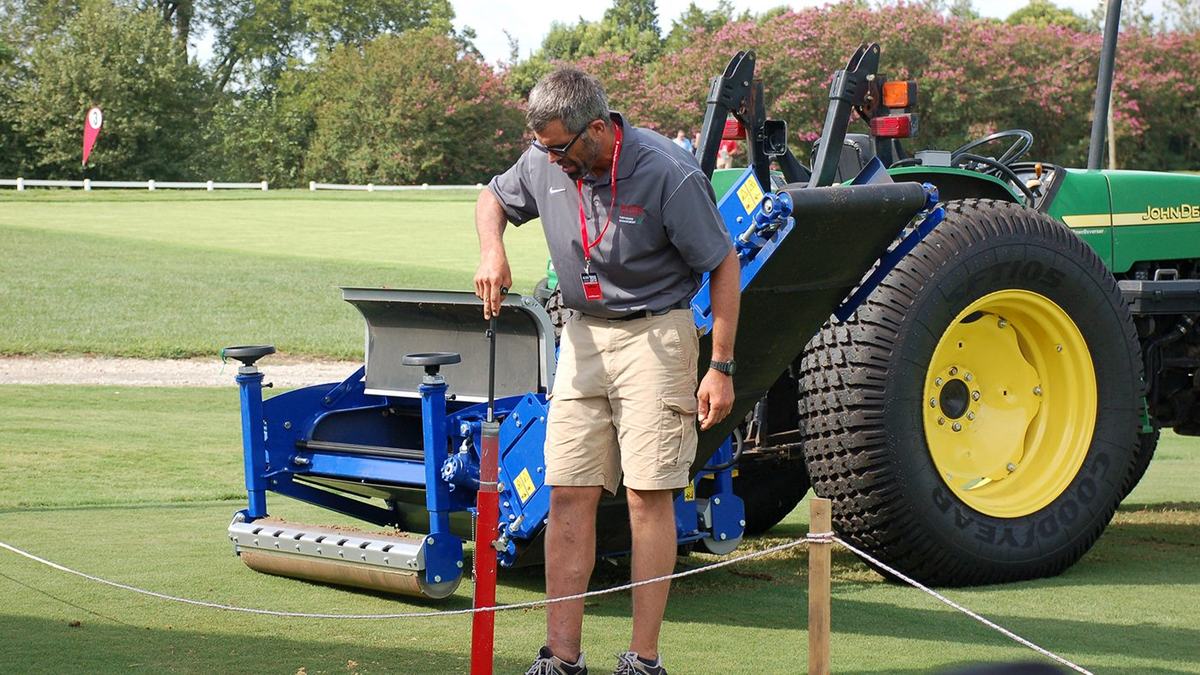 Turf student with tractor on golf course green