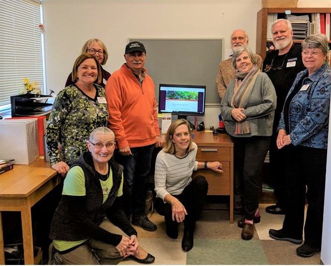 group of EMG volunteers stand near computer screen 