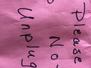 Pink paper with handwritten text: "Please do not unplug"
