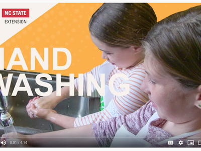 Two children washing hands at a sink, overlaid text "HAND WASHING" and NC State Extension logo