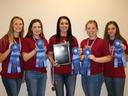 Five people in matching shirts holding blue ribbons and a plaque reading "High Senior Team 2020."