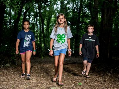 Three youth walking in the woods