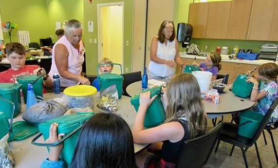 kids at tables labeling compost bins