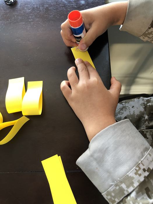 Gluing strips of paper for a sunflower craft