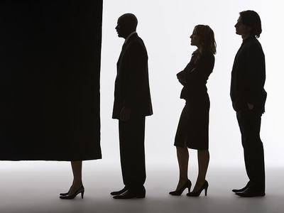 Three silhouetted professionals queued behind a voting booth curtain