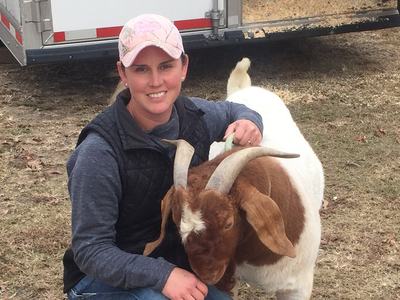 Jennifer Harrison with a horned brown and white goat