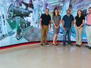 Five people standing in front of a very large screen wall
